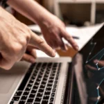 Hand pointing at keyboard in business | Cybersecurity for Small Business: Protecting Against Phishing, Ransomware, and Malware