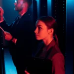 Two People Learning Cybersecurity Terms in Server Room Mood Lighting